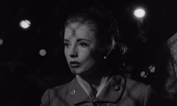 Movie still from “The Killing” (1956), directed by Stanley Kubrick – A black - and - white photo of a woman in a suit; Close Up shot, Low angle