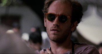 Movie still from “The Killing Fields” (1984), directed by Roland Joffé – A person wearing sunglasses; Close Up shot, Low angle