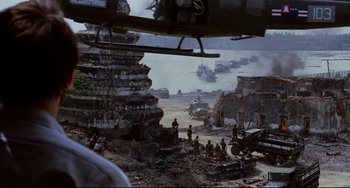Movie still from “The Killing Fields” (1984), directed by Roland Joffé – A group of people standing on top of a dirt field; Extreme Wide shot, High angle