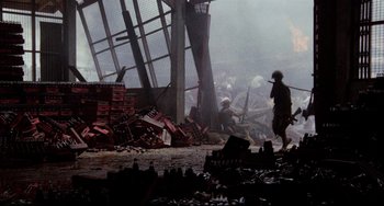 Movie still from “The Killing Fields” (1984), directed by Roland Joffé – A soldier is walking through the ruins of a building; Extreme Wide shot, High angle