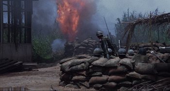 Movie still from “The Killing Fields” (1984), directed by Roland Joffé – A group of men standing on top of a pile of dirt; Wide shot, High angle