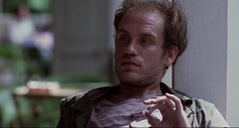 Movie still from “The Killing Fields” (1984), directed by Roland Joffé – A person holding a cell phone; Close Up shot, Low angle