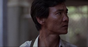 Movie still from “The Killing Fields” (1984), directed by Roland Joffé – An asian man with short black hair looking to his left; Close Up shot, Low angle