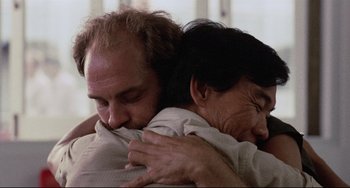 Movie still from “The Killing Fields” (1984), directed by Roland Joffé – A man and a woman hugging each other in a room; Close Up shot, Low angle