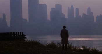 Movie still from “The Killing Fields” (1984), directed by Roland Joffé – A man standing in front of a body of water; Extreme Wide shot, Over the shoulder angle