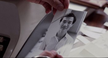 Movie still from “The Killing Fields” (1984), directed by Roland Joffé – A person holding a picture of a man; Extreme Close Up shot, Overhead angle