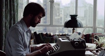 Movie still from “The Killing Fields” (1984), directed by Roland Joffé – A man is typing on an old fashioned typewriter; Close Up shot, High angle