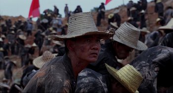 Movie still from “The Killing Fields” (1984), directed by Roland Joffé – A group of people wearing hats and standing on a hill; Close Up shot, Low angle