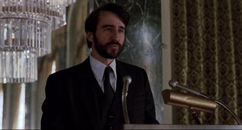 Movie still from “The Killing Fields” (1984), directed by Roland Joffé – A man wearing a suit and tie standing in front of a microphone; Close Up shot, Low angle