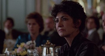 Movie still from “The Killing Fields” (1984), directed by Roland Joffé – A person sitting at a table; Close Up shot, Over the shoulder angle