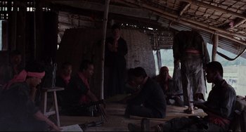 A group of people sitting around in a hut