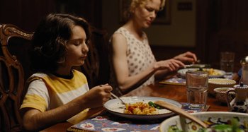 Movie still from “The Killing of a Sacred Deer” (2017), directed by Yorgos Lanthimos – Two people sitting at a table with a plate of food; Medium shot, Over the shoulder angle
