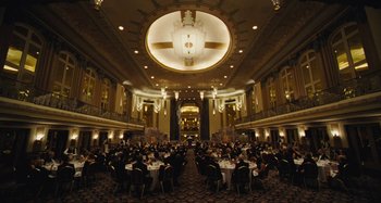 Movie still from “The Killing of a Sacred Deer” (2017), directed by Yorgos Lanthimos – A group of people sitting at tables in a large room; Extreme Wide shot, High angle