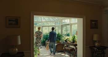 Movie still from “The Killing of a Sacred Deer” (2017), directed by Yorgos Lanthimos – A man and a woman walking into a room with plants; Wide shot, Over the shoulder angle