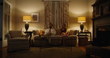 Movie still from “The Killing of a Sacred Deer” (2017), directed by Yorgos Lanthimos – A man and a woman sitting on a couch in a living room; Wide shot, Low angle