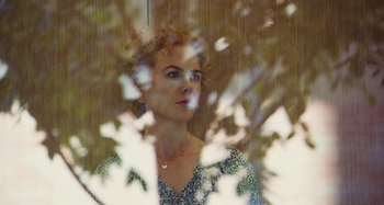 Movie still from “The Killing of a Sacred Deer” (2017), directed by Yorgos Lanthimos – A woman looking out of a window at the trees; Close Up shot, High angle