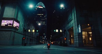 Movie still from “The Killing of a Sacred Deer” (2017), directed by Yorgos Lanthimos – A person riding a motorcycle down a street at night; Extreme Wide shot, Low angle