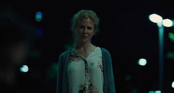 Movie still from “The Killing of a Sacred Deer” (2017), directed by Yorgos Lanthimos – A woman standing in the dark wearing a floral shirt; Close Up shot, Over the shoulder angle