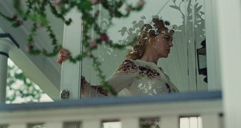 Movie still from “The Killing of a Sacred Deer” (2017), directed by Yorgos Lanthimos – A woman standing in front of a glass window; Medium shot, Low angle
