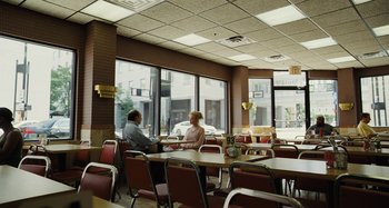 Movie still from “The Killing of a Sacred Deer” (2017), directed by Yorgos Lanthimos – A man and a woman sitting at a table in front of a window; Wide shot, High angle