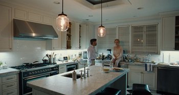Movie still from “The Killing of a Sacred Deer” (2017), directed by Yorgos Lanthimos – Two people are standing in a kitchen with a sink; Wide shot, Over the shoulder angle