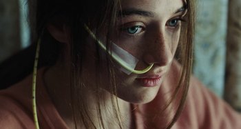 Movie still from “The Killing of a Sacred Deer” (2017), directed by Yorgos Lanthimos – A person with a bandage on their face; Close Up shot, High angle