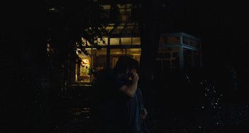 Movie still from “The Killing of a Sacred Deer” (2017), directed by Yorgos Lanthimos – A man sitting on a bench in front of a building; Wide shot, Low angle