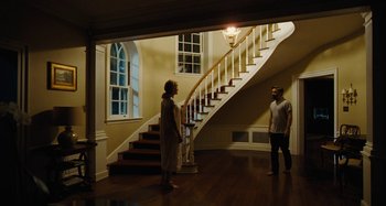 Movie still from “The Killing of a Sacred Deer” (2017), directed by Yorgos Lanthimos – A man and a woman standing in front of a spiral staircase; Wide shot, Low angle