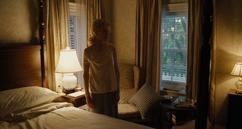 Movie still from “The Killing of a Sacred Deer” (2017), directed by Yorgos Lanthimos – A woman standing in front of a window in a room; Wide shot, Over the shoulder angle