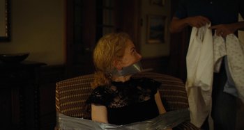 Movie still from “The Killing of a Sacred Deer” (2017), directed by Yorgos Lanthimos – A woman sitting in a chair taped to the side of her face; Medium shot, Over the shoulder angle