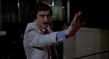 Movie still from “The King of Comedy” (1982), directed by Martin Scorsese – A man that is wearing a suit and tie; Close Up shot, Over the shoulder angle