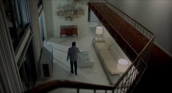 Movie still from “The King of Comedy” (1982), directed by Martin Scorsese – A man standing in front of a couch in a living room; Extreme Wide shot, High angle