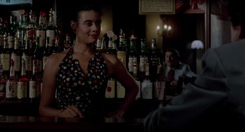 Movie still from “The King of Comedy” (1982), directed by Martin Scorsese – A woman standing at a bar in front of bottles of alcohol; Medium shot, Over the shoulder angle