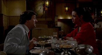 Movie still from “The King of Comedy” (1982), directed by Martin Scorsese – A man and a woman sitting at a table with plates of food on it; Medium shot, Over the shoulder angle