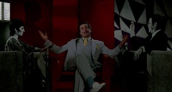 Movie still from “The King of Comedy” (1982), directed by Martin Scorsese – A man sitting in a chair wearing headphones; Medium shot, Low angle