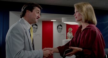 Movie still from “The King of Comedy” (1982), directed by Martin Scorsese – A man and a woman shaking hands in a room; Medium shot, Over the shoulder angle