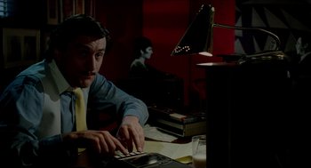 Movie still from “The King of Comedy” (1982), directed by Martin Scorsese – A man sitting in front of a computer desk; Medium shot, High angle