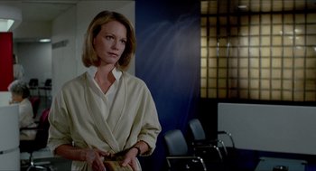 Movie still from “The King of Comedy” (1982), directed by Martin Scorsese – A woman standing in front of chairs in a room; Medium shot, Over the shoulder angle