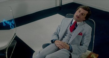 Movie still from “The King of Comedy” (1982), directed by Martin Scorsese – A man in a suit and tie sitting in a chair; Medium shot, High angle