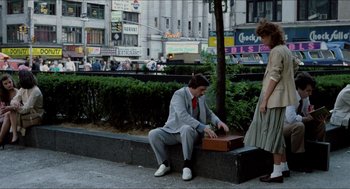 Movie still from “The King of Comedy” (1982), directed by Martin Scorsese – A man sitting on the side of the road next to a woman; Wide shot, Low angle