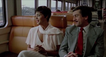 Movie still from “The King of Comedy” (1982), directed by Martin Scorsese – A man and a woman sitting on a train; Medium shot, High angle