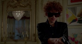 Movie still from “The King of Comedy” (1982), directed by Martin Scorsese – A woman in a black shirt holding a gun; Close Up shot, Over the shoulder angle