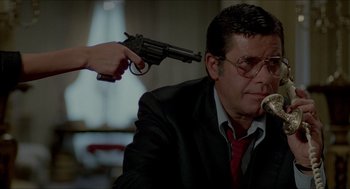 Movie still from “The King of Comedy” (1982), directed by Martin Scorsese – A man in a suit and tie holding a gun up to his head; Medium shot, Low angle