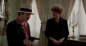 Movie still from “The King of Comedy” (1982), directed by Martin Scorsese – A man and a woman are standing next to each other holding a gun; Medium shot, Over the shoulder angle