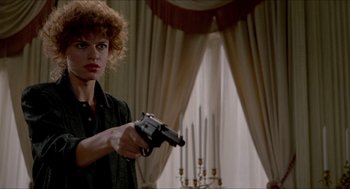 Movie still from “The King of Comedy” (1982), directed by Martin Scorsese – A woman holding a gun while standing in a room; Medium shot, Low angle