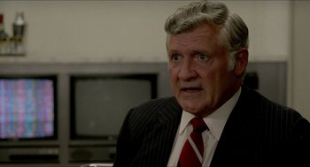 Movie still from “The King of Comedy” (1982), directed by Martin Scorsese – An older man wearing a suit and red tie; Close Up shot, Over the shoulder angle