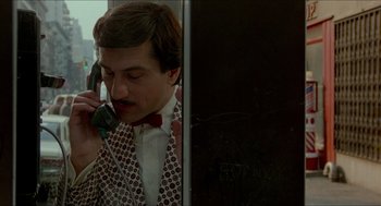 Movie still from “The King of Comedy” (1982), directed by Martin Scorsese – A man wearing a suit and tie talking on a phone; Close Up shot, Over the shoulder angle