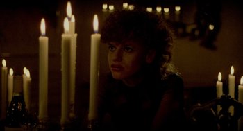 Movie still from “The King of Comedy” (1982), directed by Martin Scorsese – A woman sitting in front of a lit candle holder; Close Up shot, Low angle