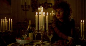 Movie still from “The King of Comedy” (1982), directed by Martin Scorsese – A woman sitting at a dinner table with candles; Medium shot, Over the shoulder angle