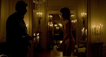 Movie still from “The King of Comedy” (1982), directed by Martin Scorsese – A woman standing in front of a man in front of candles in a living room; Medium shot, Over the shoulder angle
